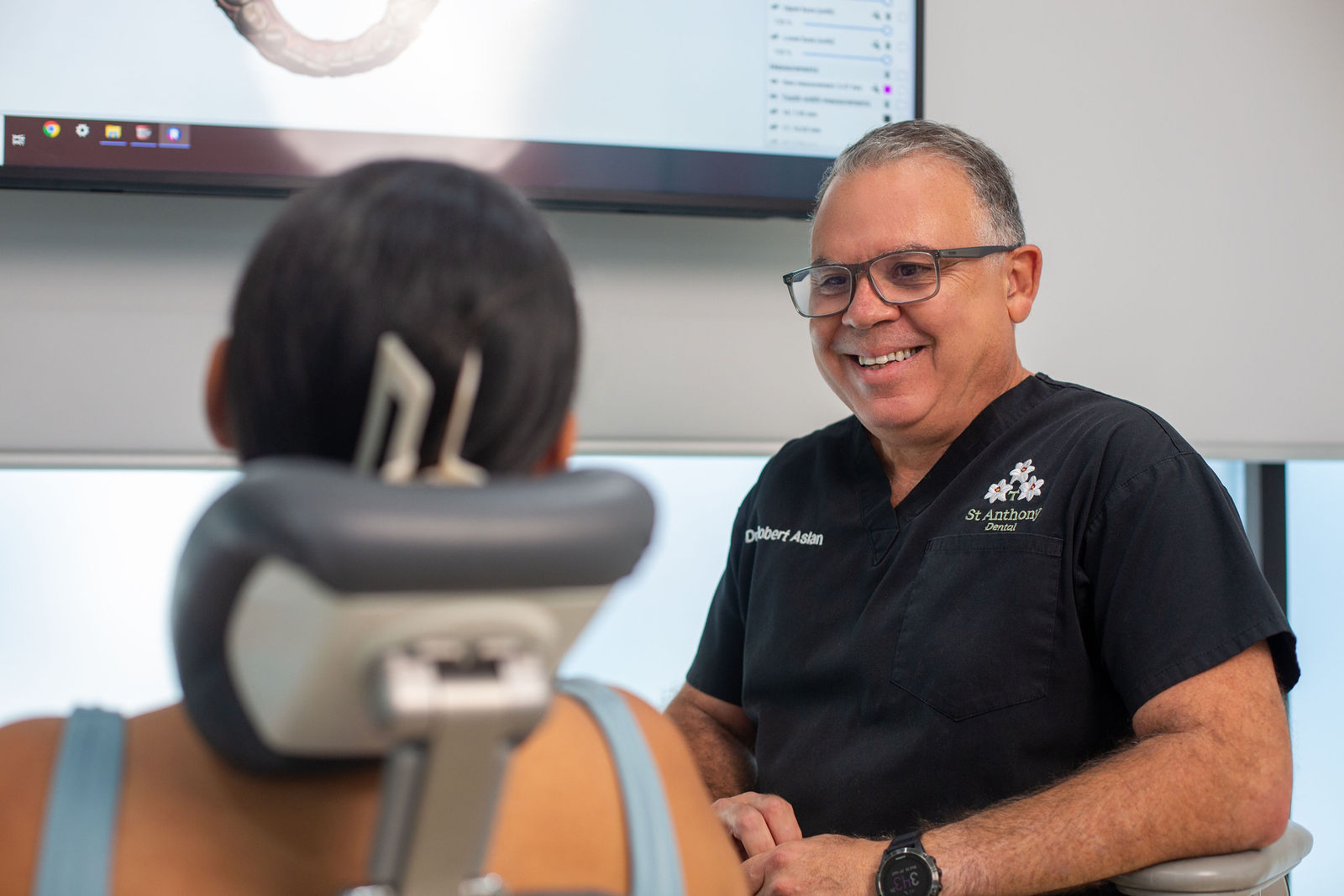 Dr Aslan smiling warmly and reassuringly in the dental chair area