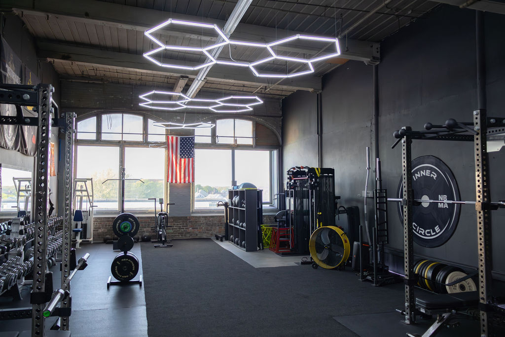 Inner Circle Training Facility — main floor with hex lights and branded racks
