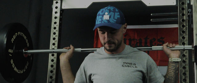 Athlete performing barbell back squat at Inner Circle