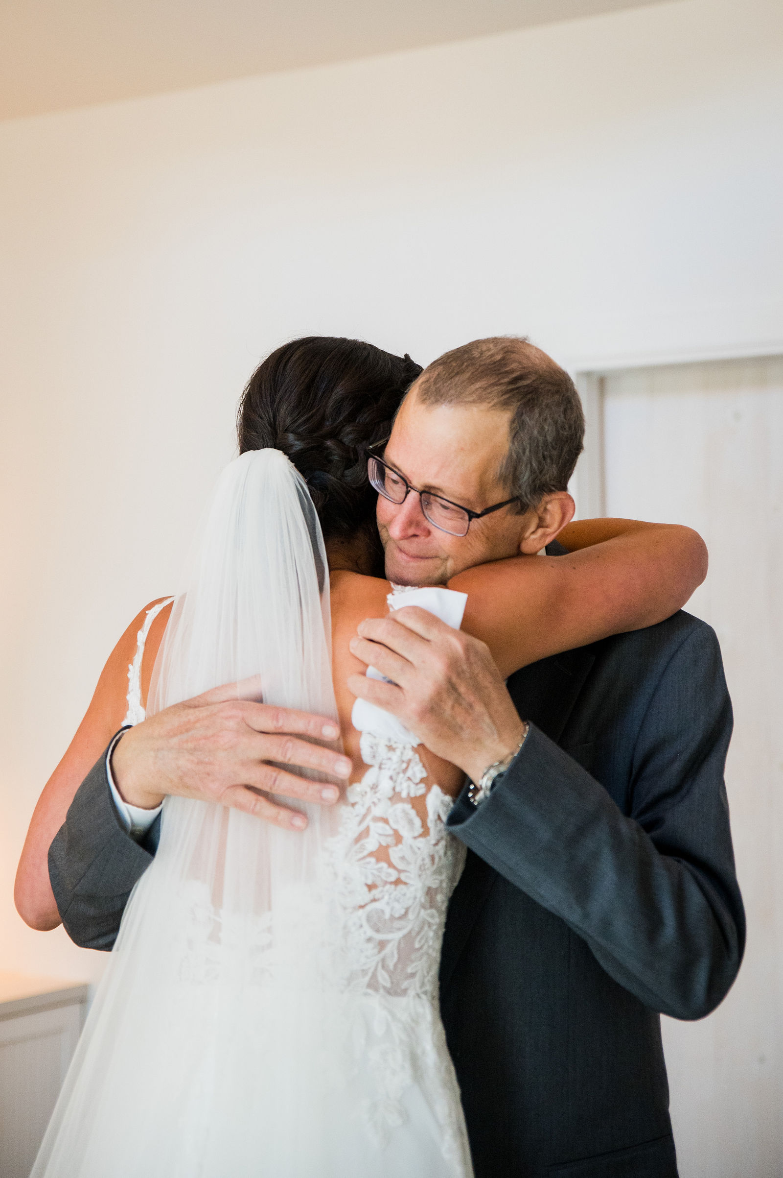 Bride hugging her father before the ceremony at The Barn at Raccoon Creek in Littleton, Colorado
