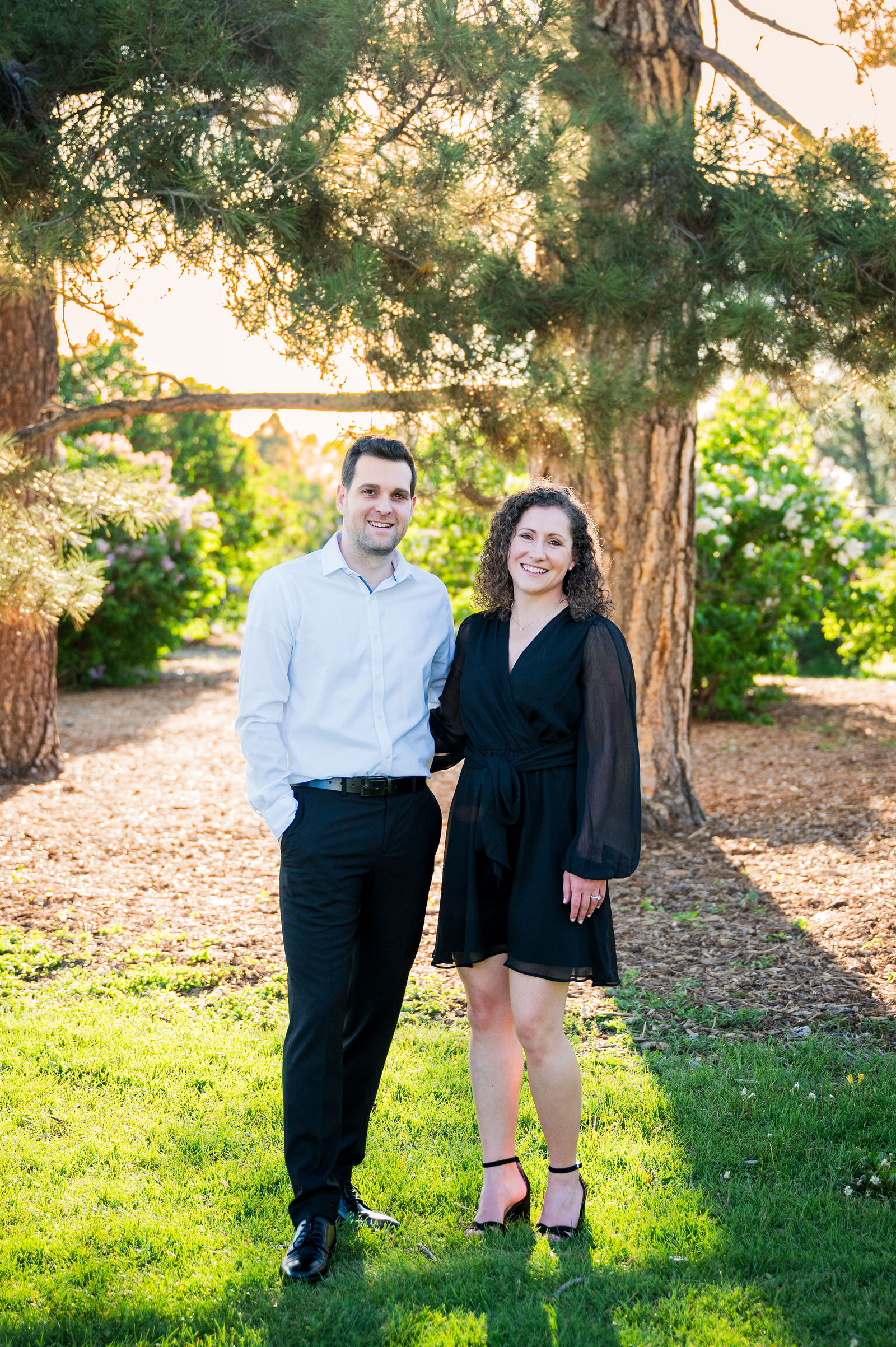 Couple in a black dress with sheer sleeves beside a crisp white shirt and dark trousers in Colorado