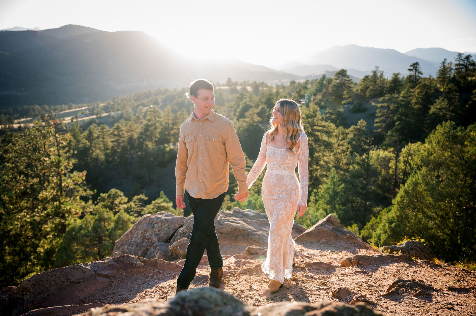 Colorado couple standing on a rock outcrop overlooking the foothills