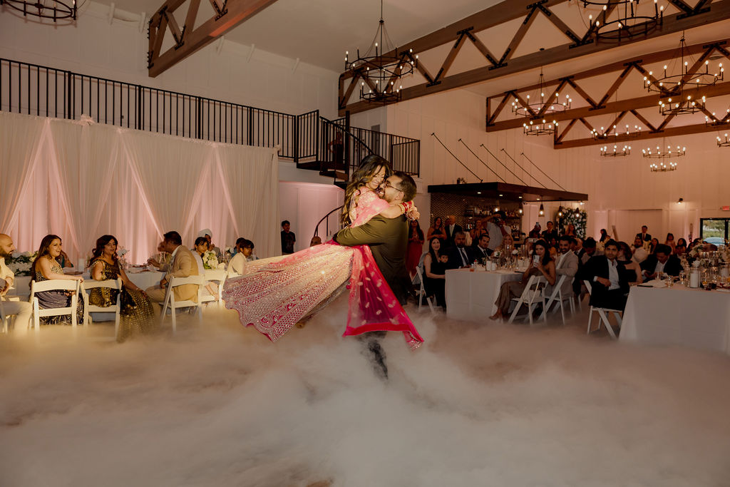Wide reception first dance showing Evanelle Vineyards timber trusses, chandeliers, balcony, spiral staircase, bar, tables and guests
