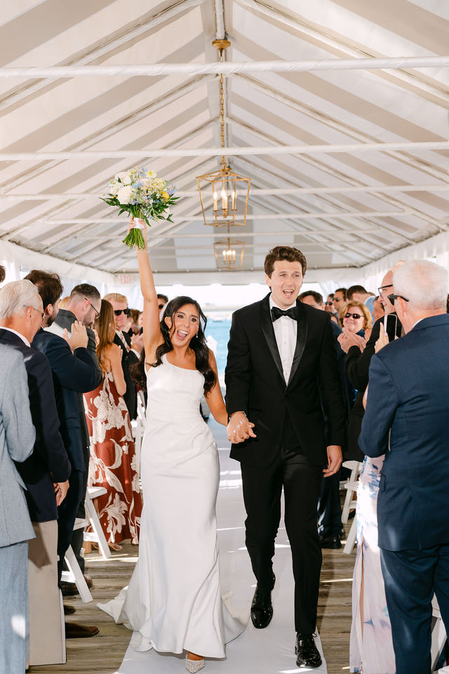 Drew and Julie celebrating as they walk back up the aisle — Regatta Place, Newport, Rhode Island