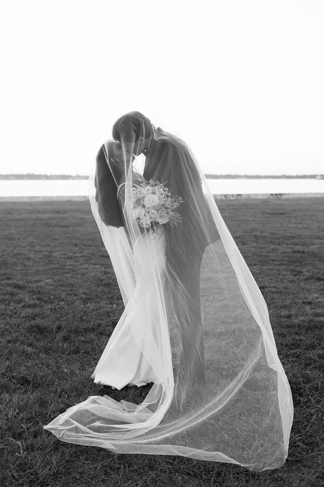Drew and Julie embracing beneath Julie’s veil in black and white — Regatta Place, Newport, Rhode Island