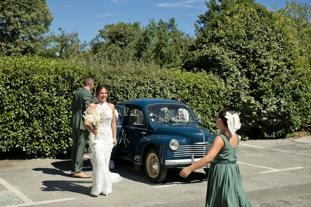 Audrey près de la voiture ancienne bleue, le jour de son mariage.