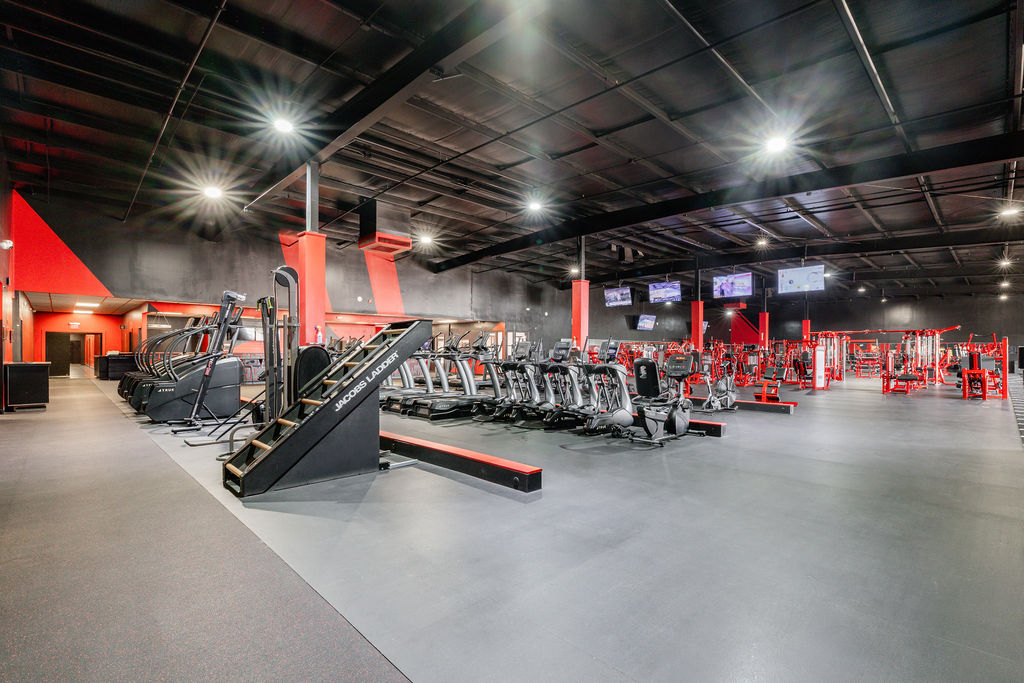 Wide cinematic panoramic of TB Fitness Club full fitness floor showing the scale of the facility