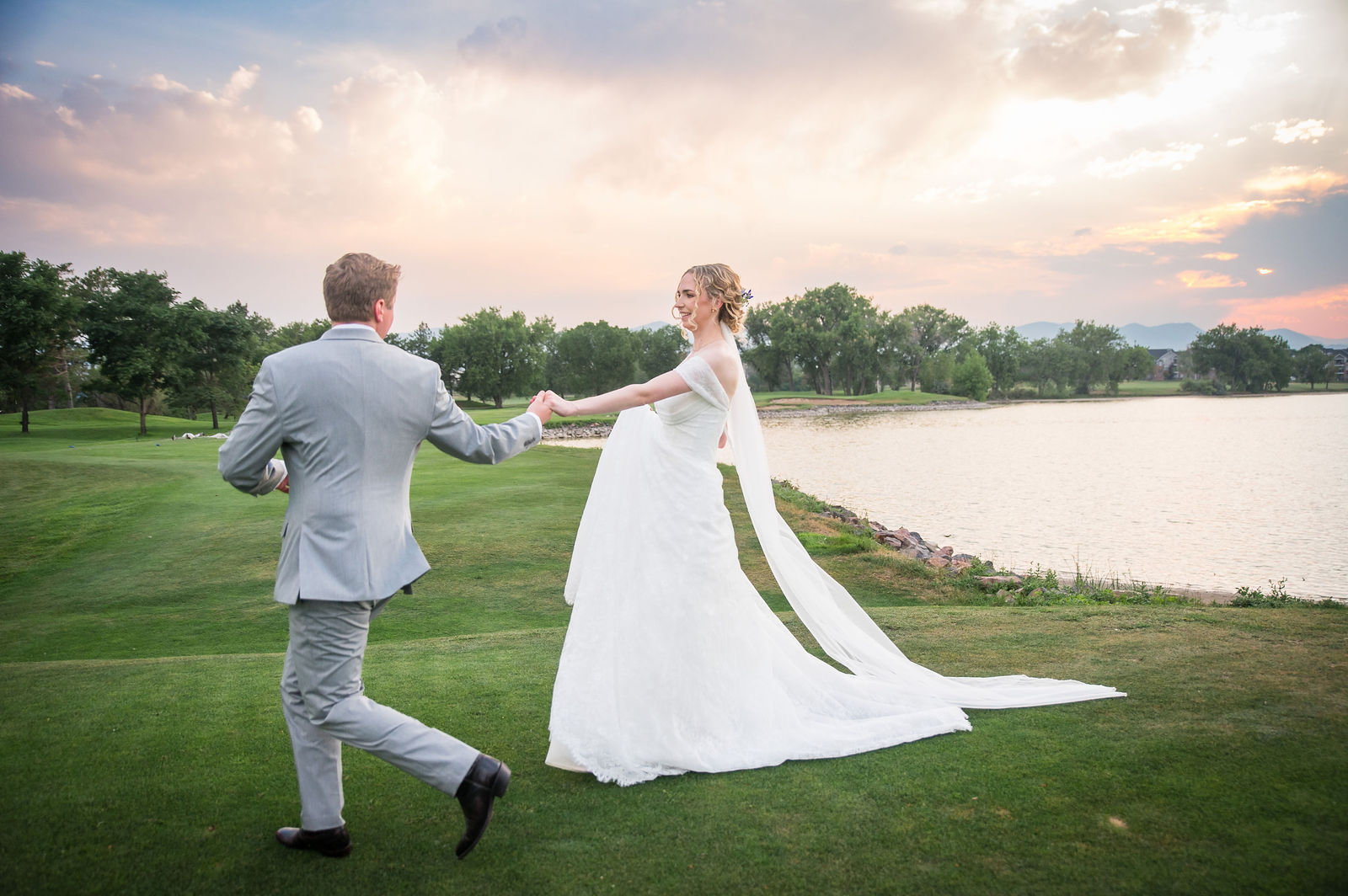 Bride and groom at golden hour beside the water at The Barn at Raccoon Creek in Littleton, Colorado