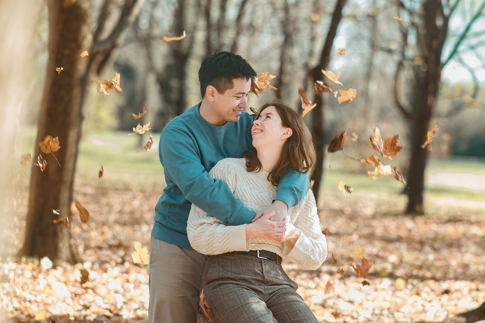 Couple entouré de feuilles d'automne volantes