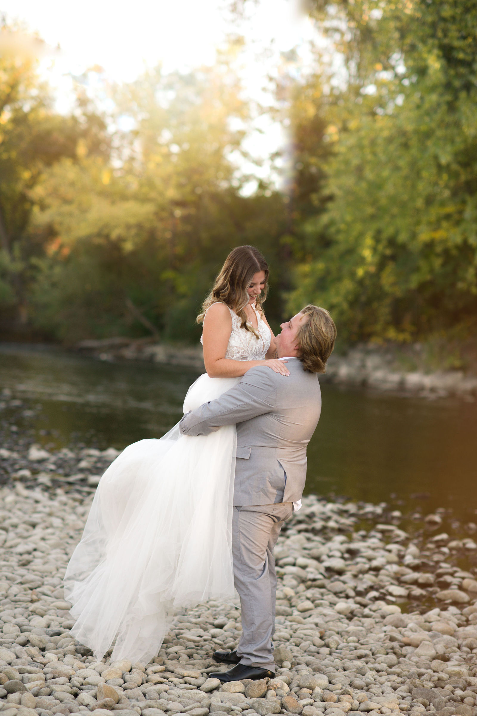 Cheyanne and Nolan celebrating beside the river in sunset light