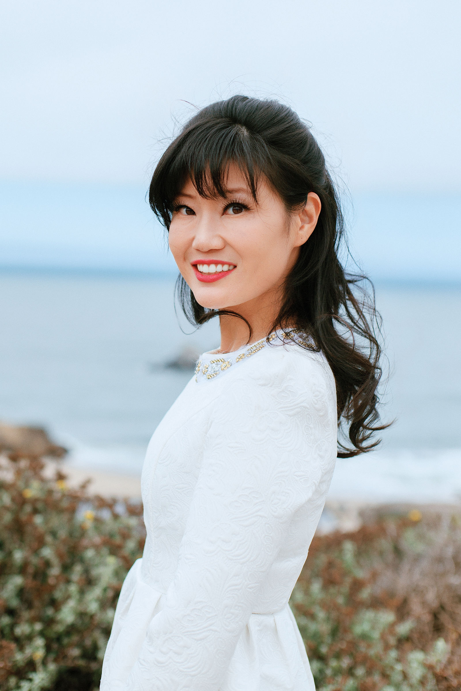 Portrait of a woman in a white dress by the ocean
