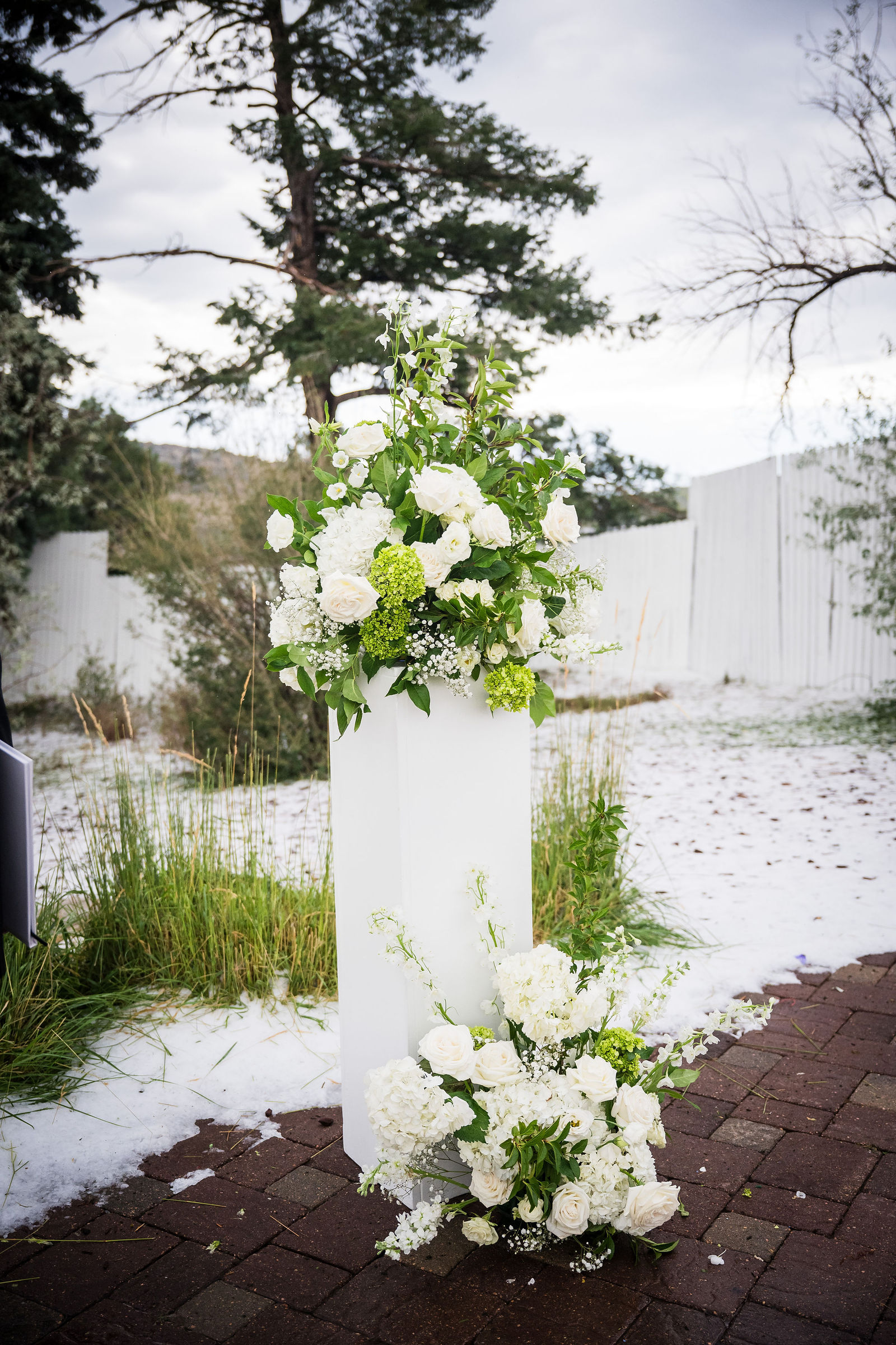 Ceremony florals with August hail on the ground at a Manor House wedding