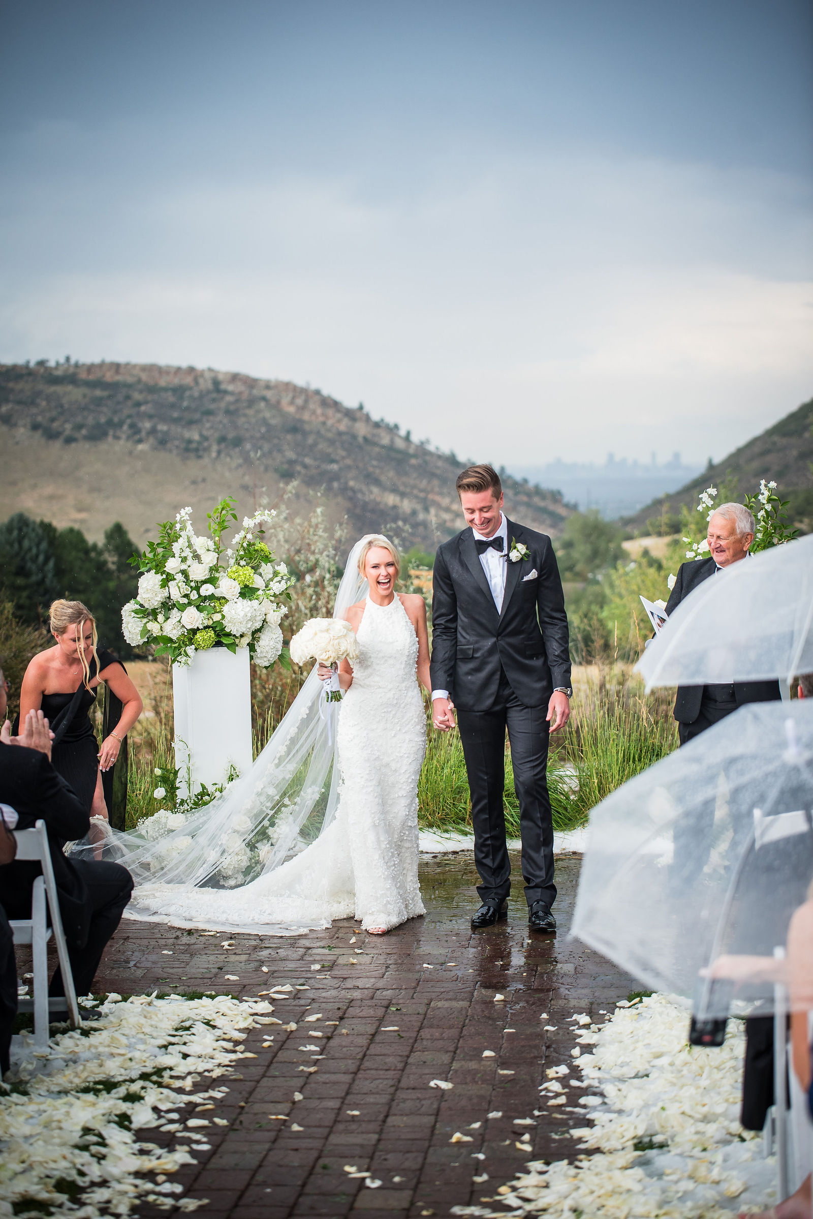 Bride and groom in the rain with the foothills behind them at The Manor House in Littleton, Colorado