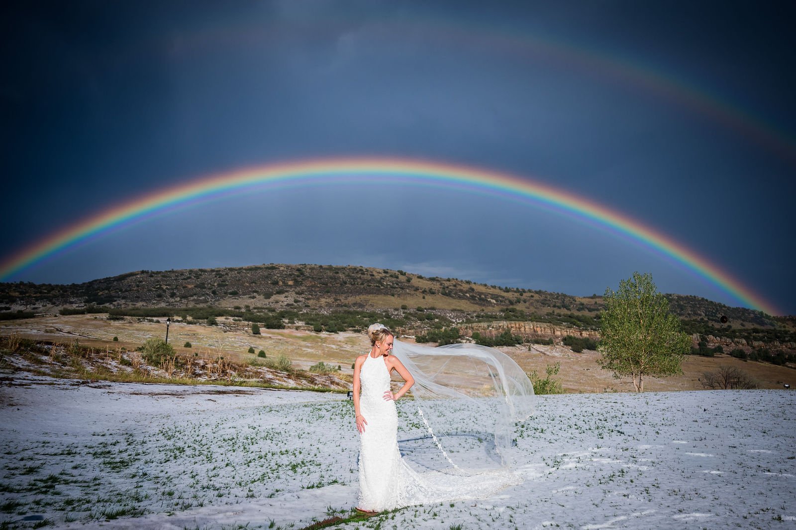 Bride with her veil under a rainbow at a Manor House wedding