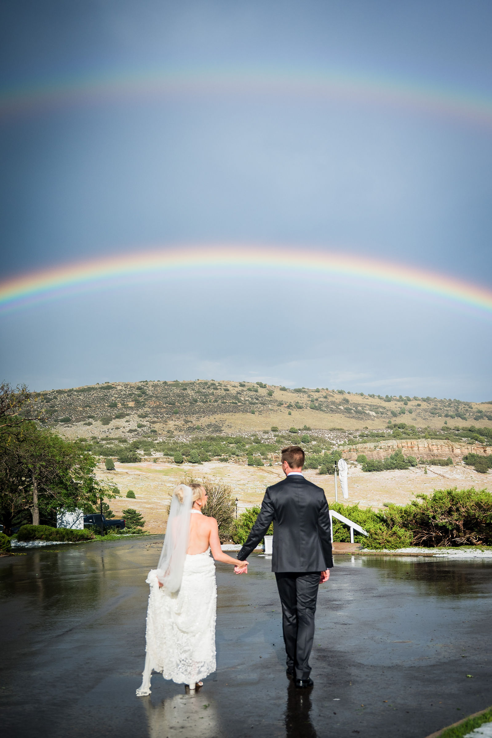 Groom lifting the bride under a double rainbow in Colorado