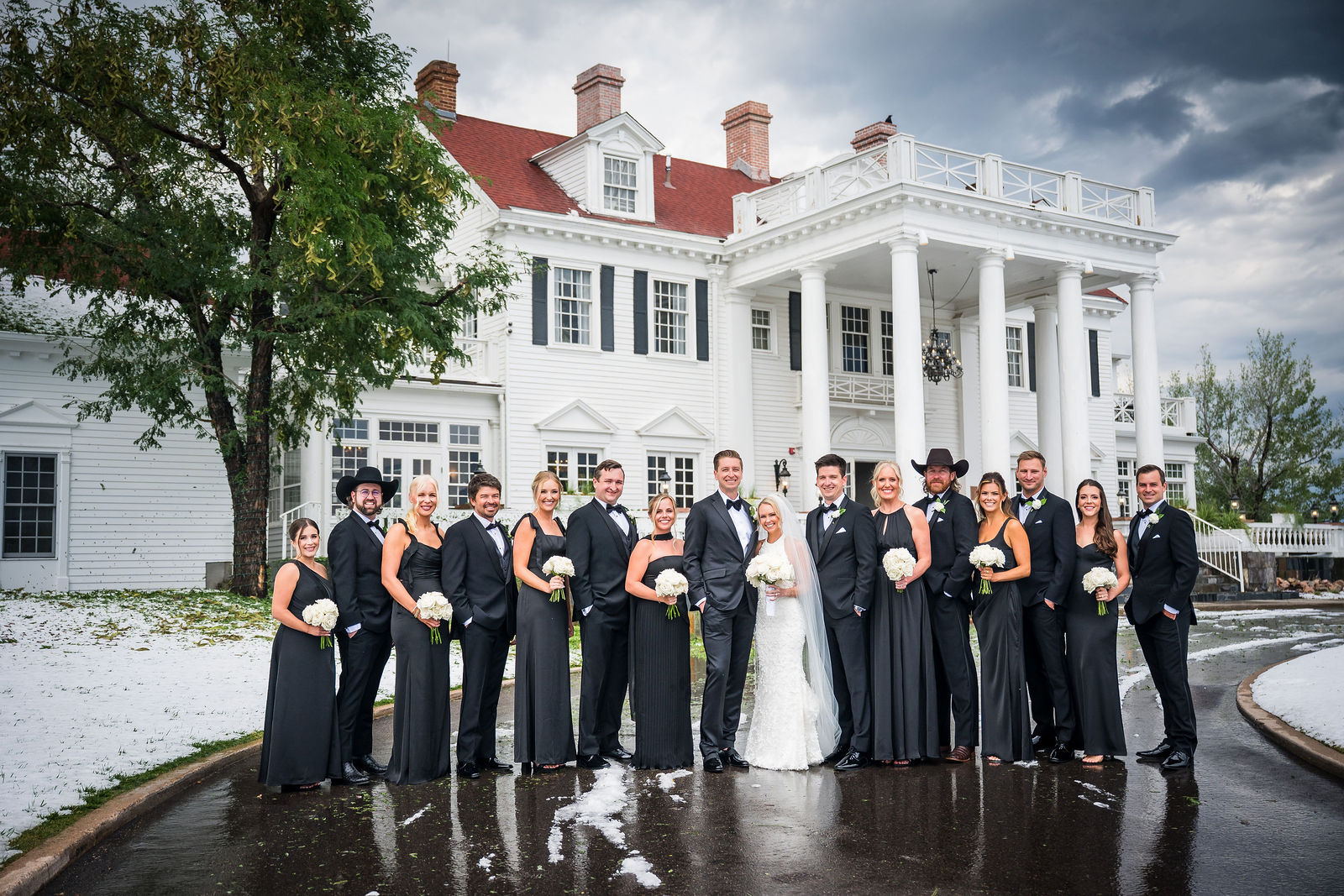 Wedding party in front of The Manor House on the hail covered drive