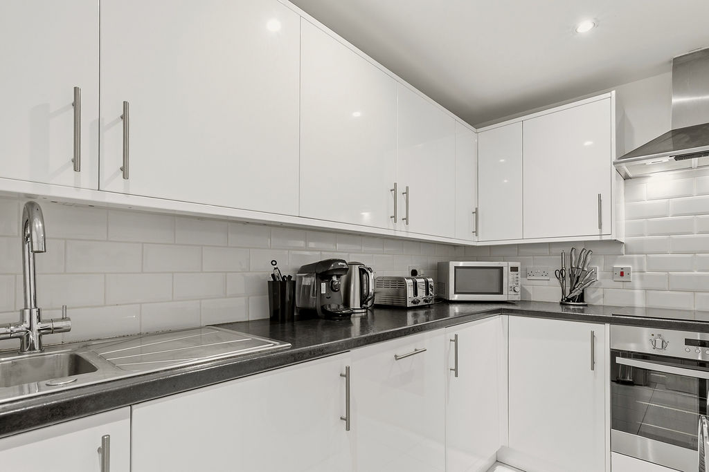 White kitchen with integrated laundry appliances