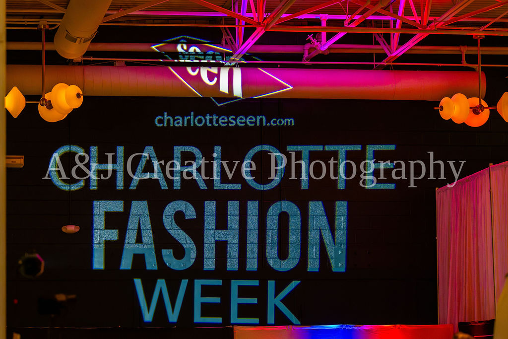 Charlotte Fashion Week event branding illuminated above the runway