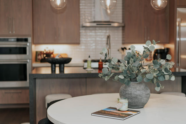 Dining table with flowers beside the pale wood kitchen
