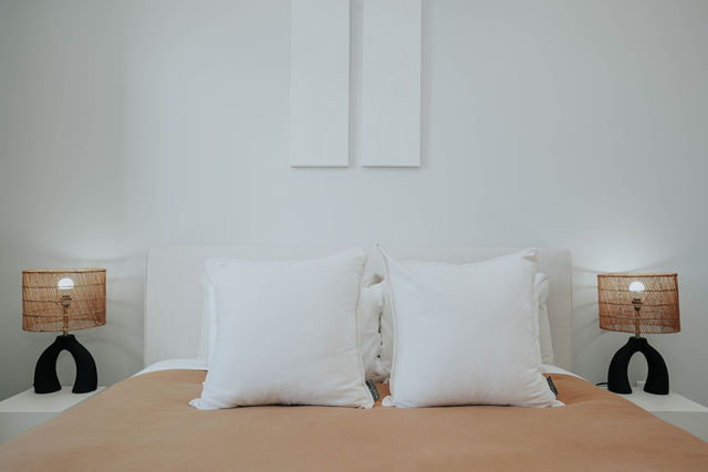 Bedroom with neutral bedding and matching bedside lamps