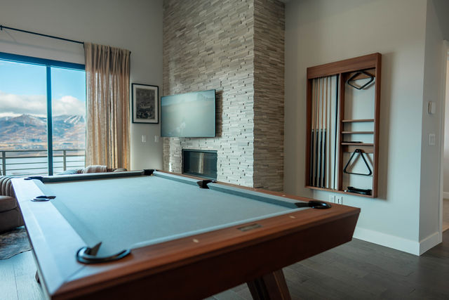 Billiard room with stone fireplace and views across the lake