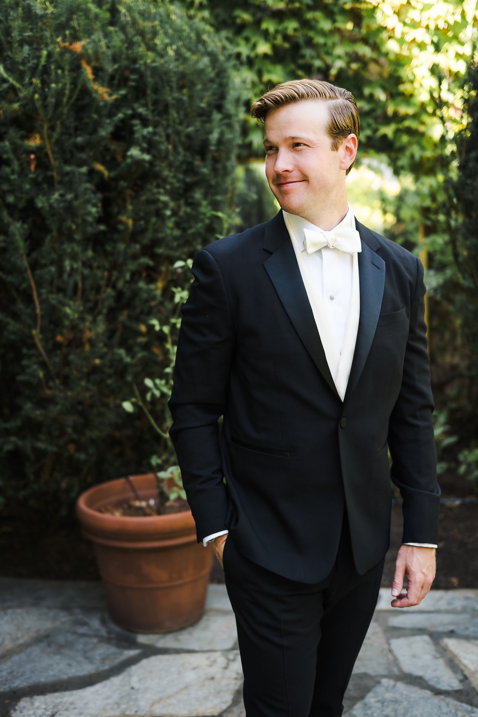 Groom portrait in a black tuxedo in a Healdsburg garden, Barndiva wedding photographer
