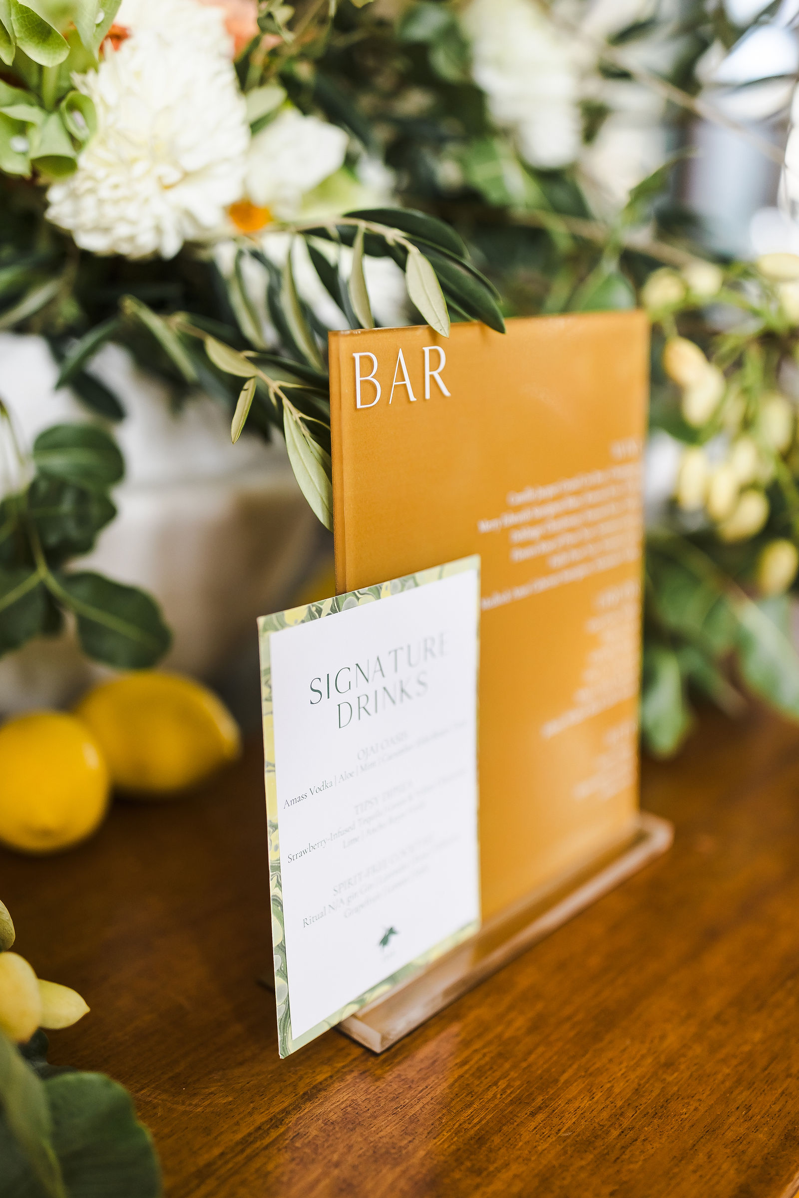 Signature cocktail bar sign with lemons and florals at a Barndiva wedding in Healdsburg