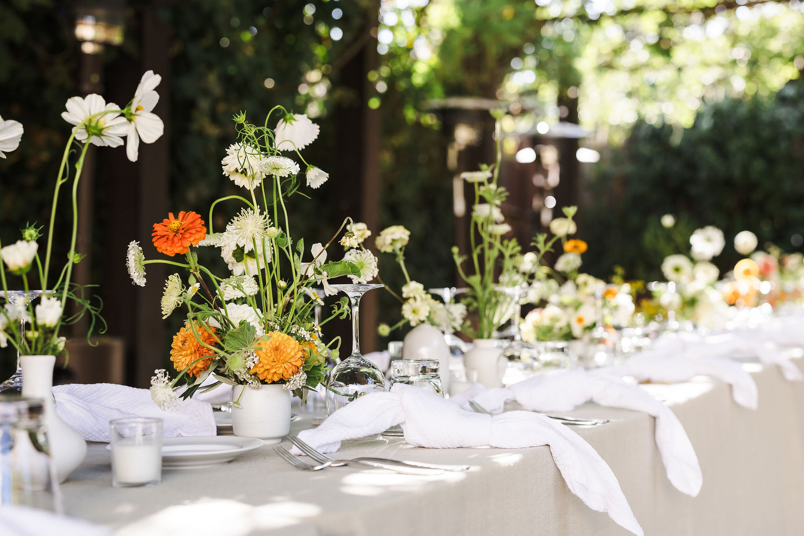 Reception tablescape with orange and white garden florals in the Barndiva garden, Healdsburg wedding photographer
