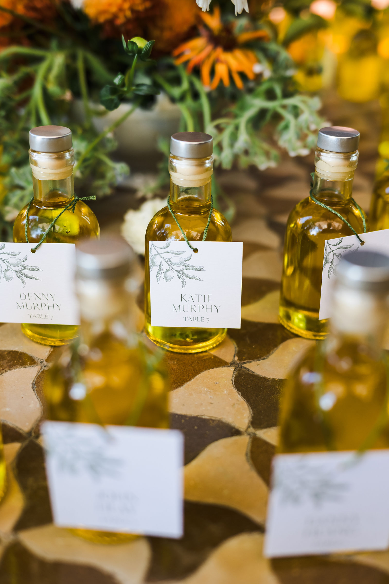 Close up of an olive oil favor and escort card detail at a Healdsburg wedding reception