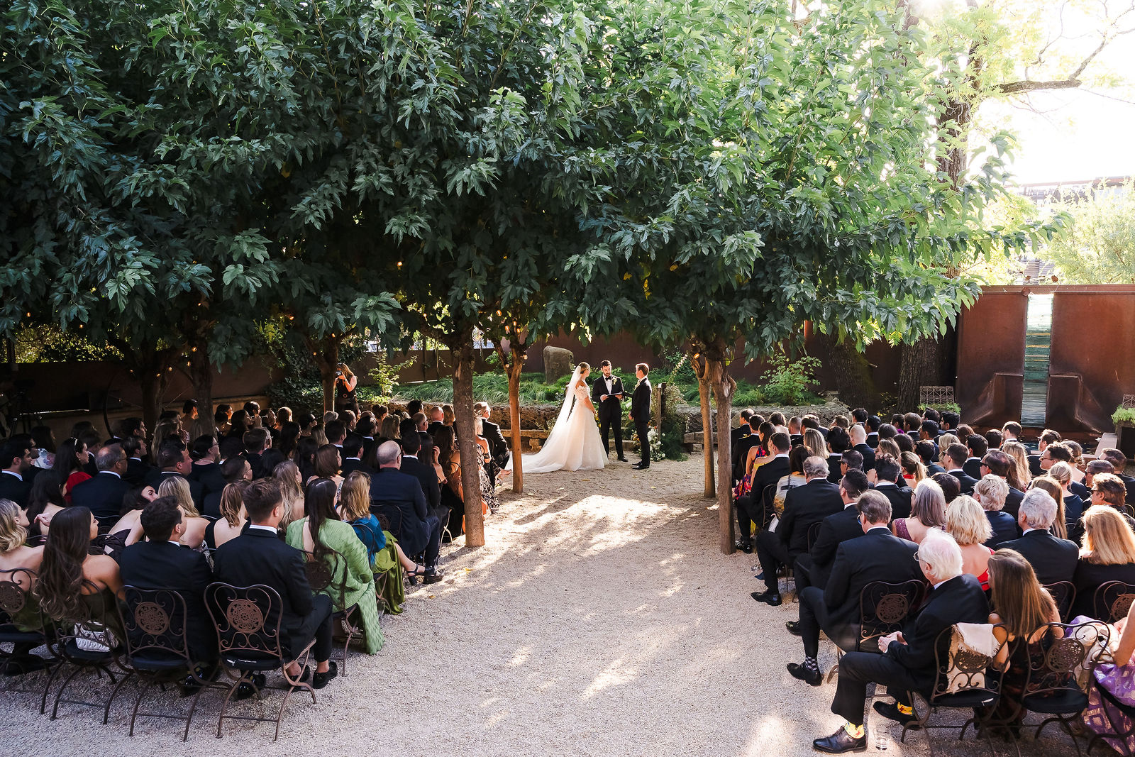 Wedding ceremony under the trees in the back garden at Barndiva in Healdsburg with 160 guests seated