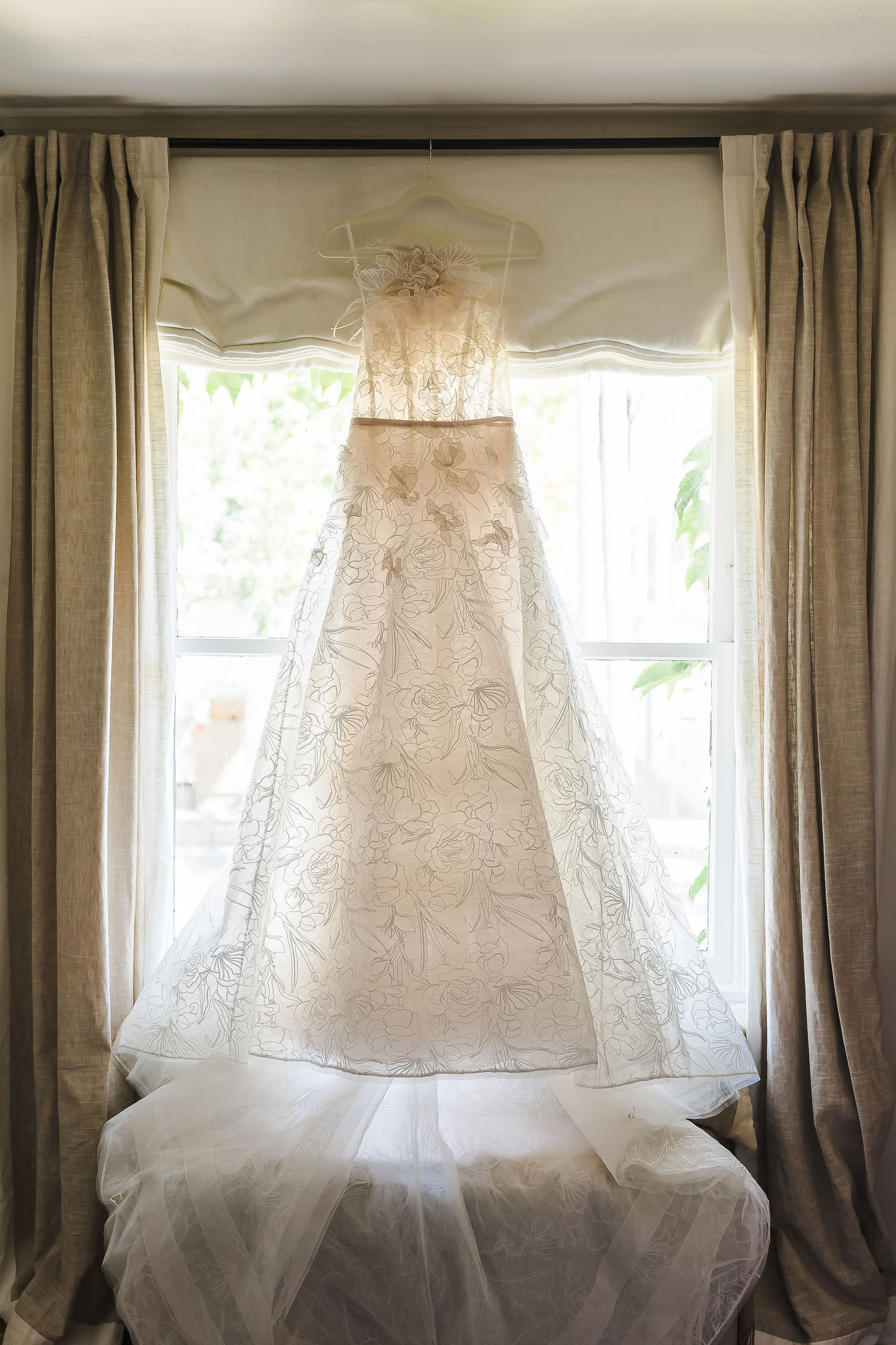 Mira Zwillinger wedding dress hanging in a window at Ivy House before a Barndiva wedding in Healdsburg California