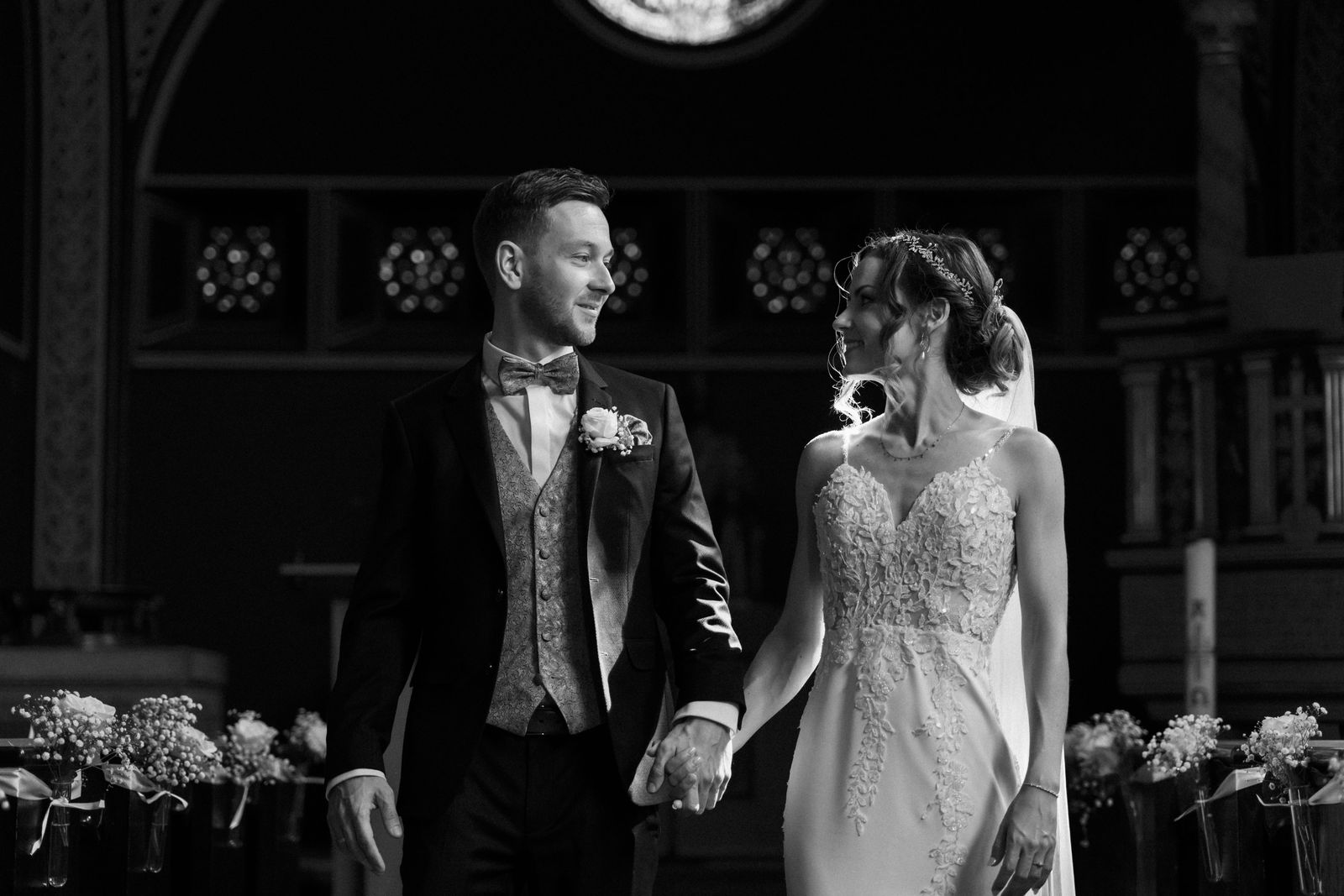 Raul und Feline halten sich an den Händen beim Auszug aus der Kirche, Hochzeitsfoto von Hochzeitsfotograf Allan Feitor in Berlin