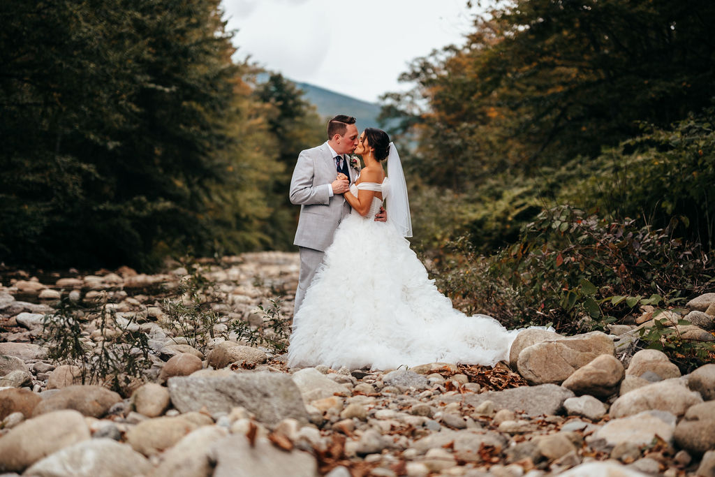 Heather and Brendan kissing in a rocky mountain stream