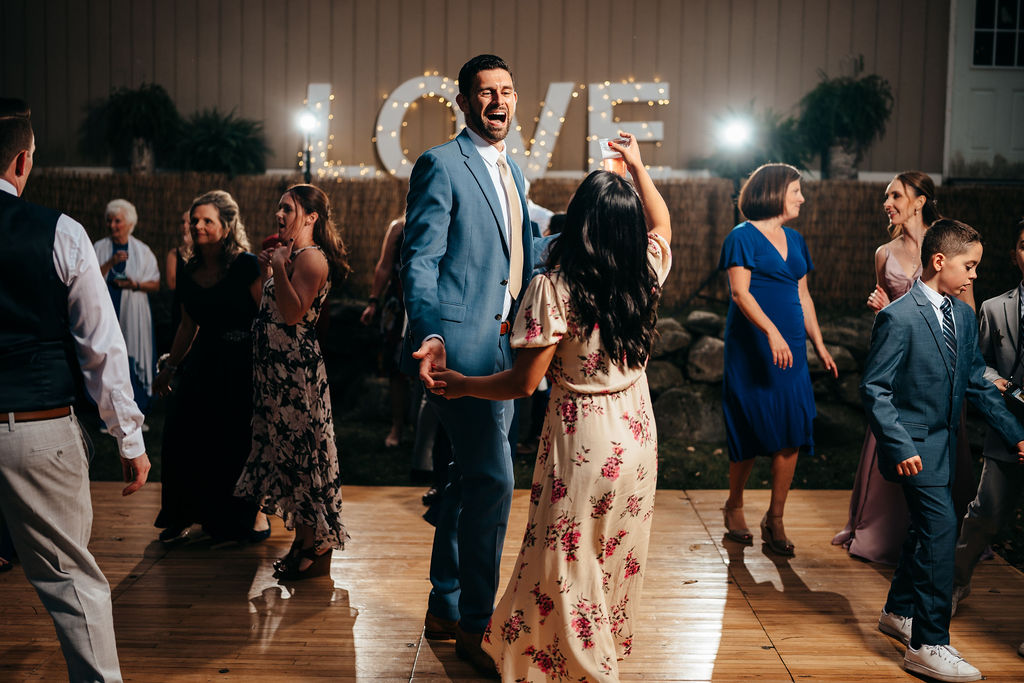 Guests dancing in front of a lit LOVE sign