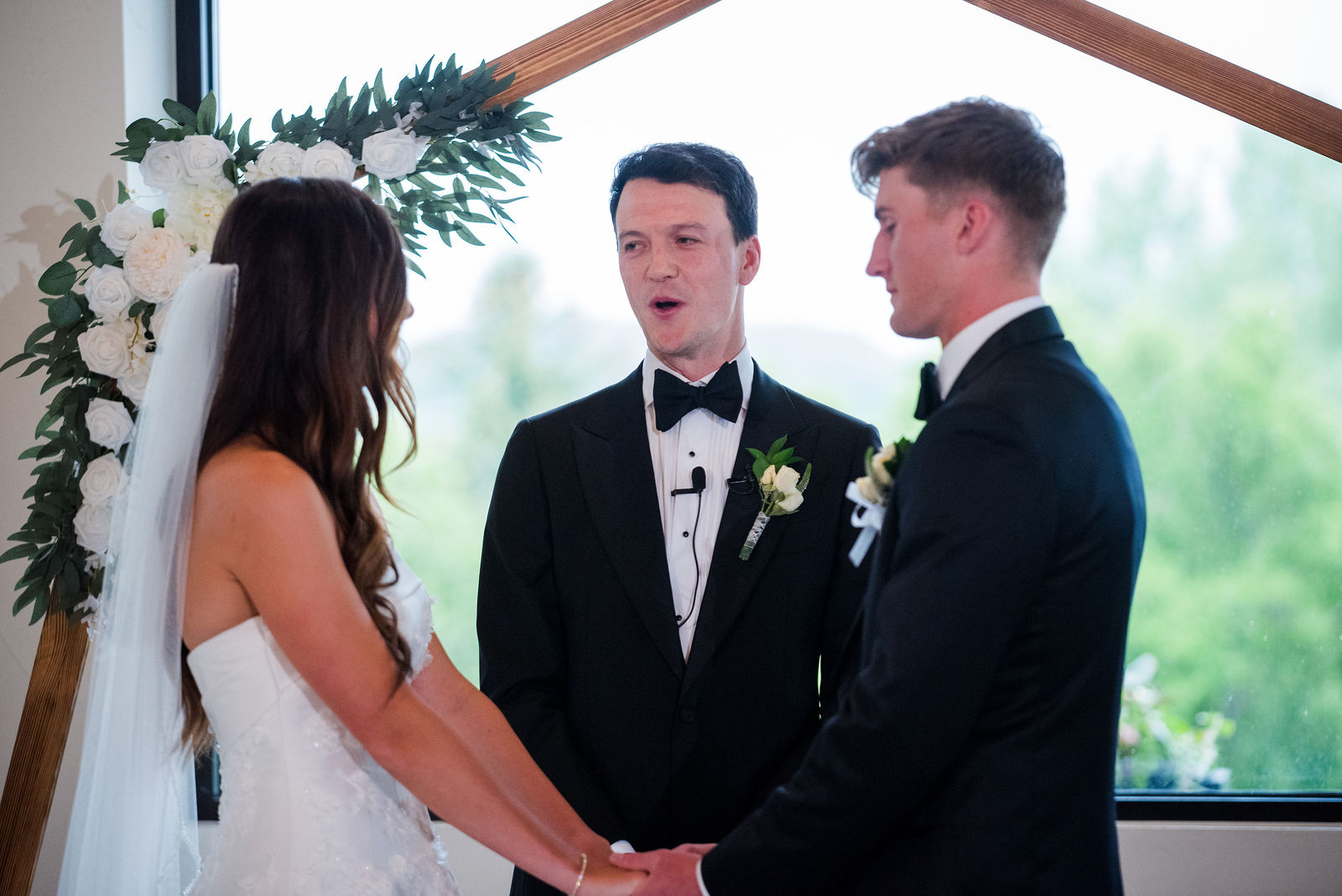 Bride and groom exchanging vows under the copper arch at The Oaks at Plum Creek