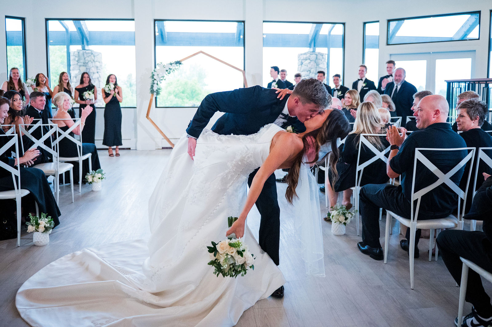 Groom dipping his bride in the aisle at The Oaks at Plum Creek