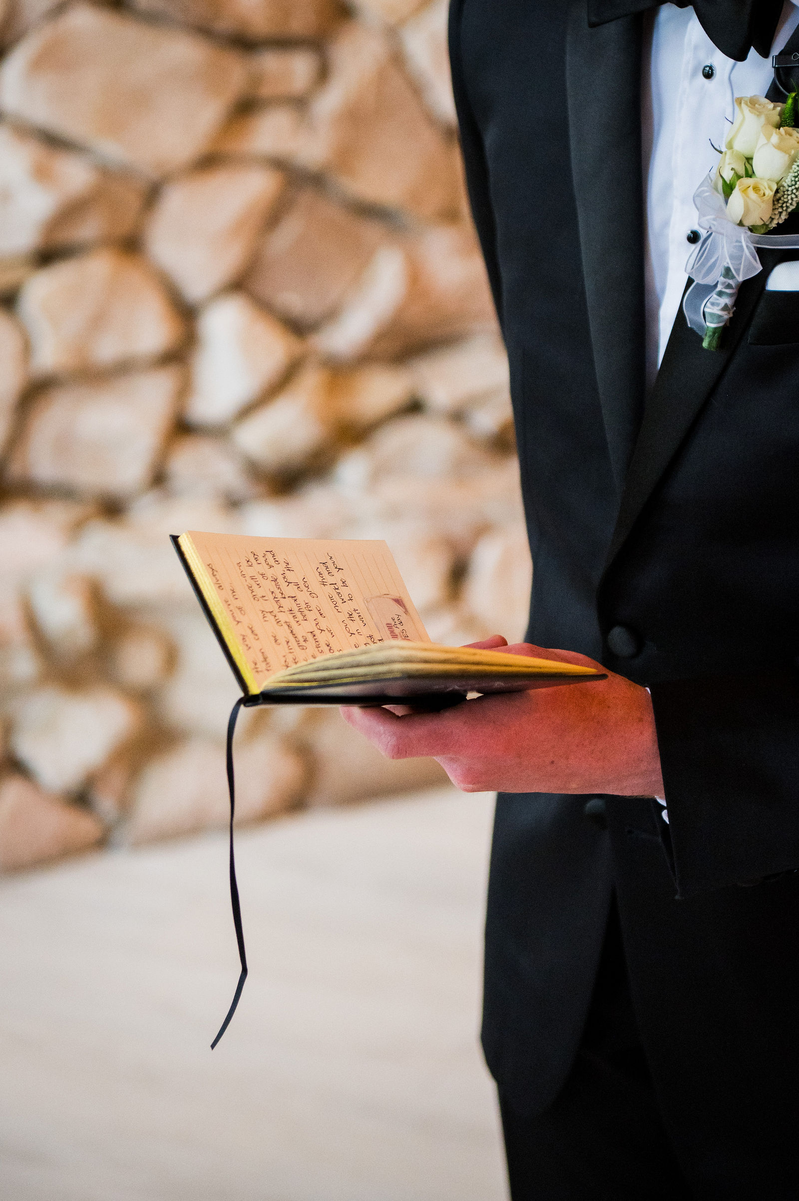Groom holding his handwritten vow book at a Castle Rock Colorado wedding