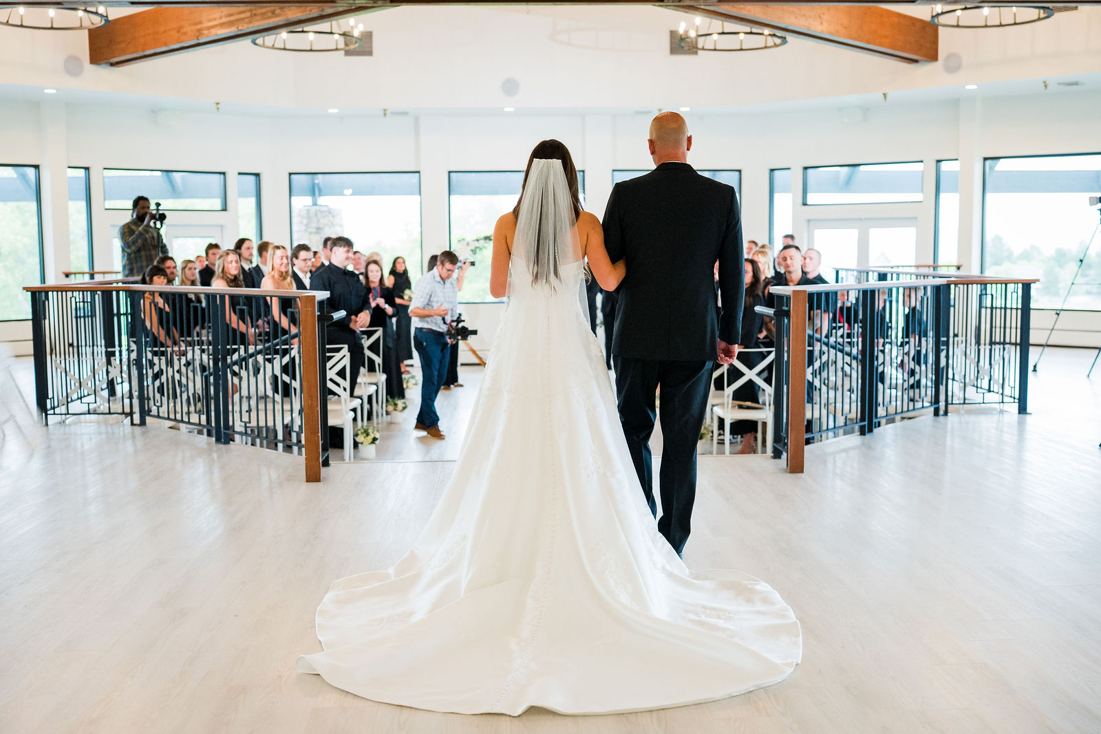 Bride walking down the aisle with her father at The Oaks at Plum Creek