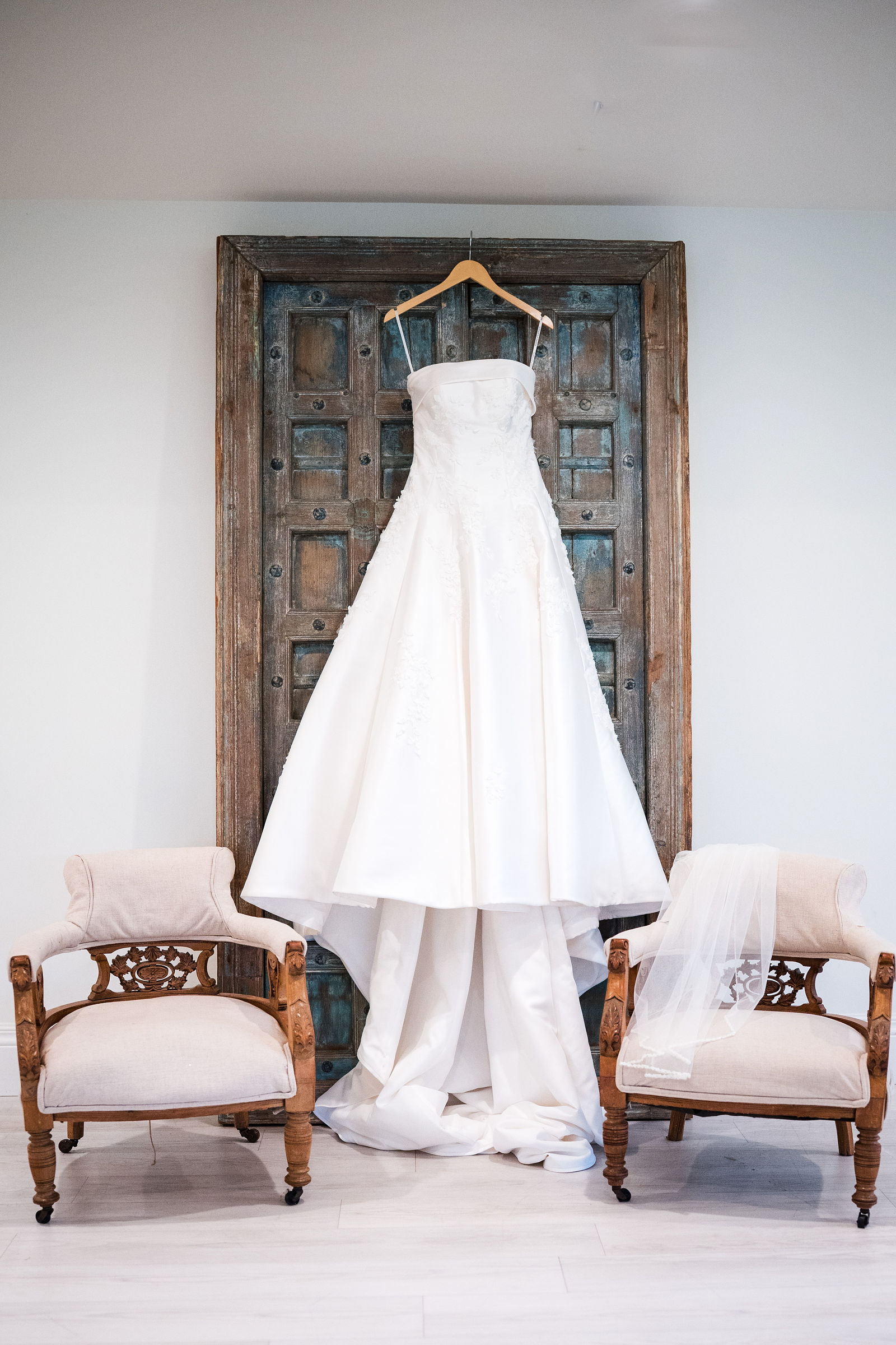Wedding dress hanging on an antique wooden door before a Castle Rock Colorado wedding