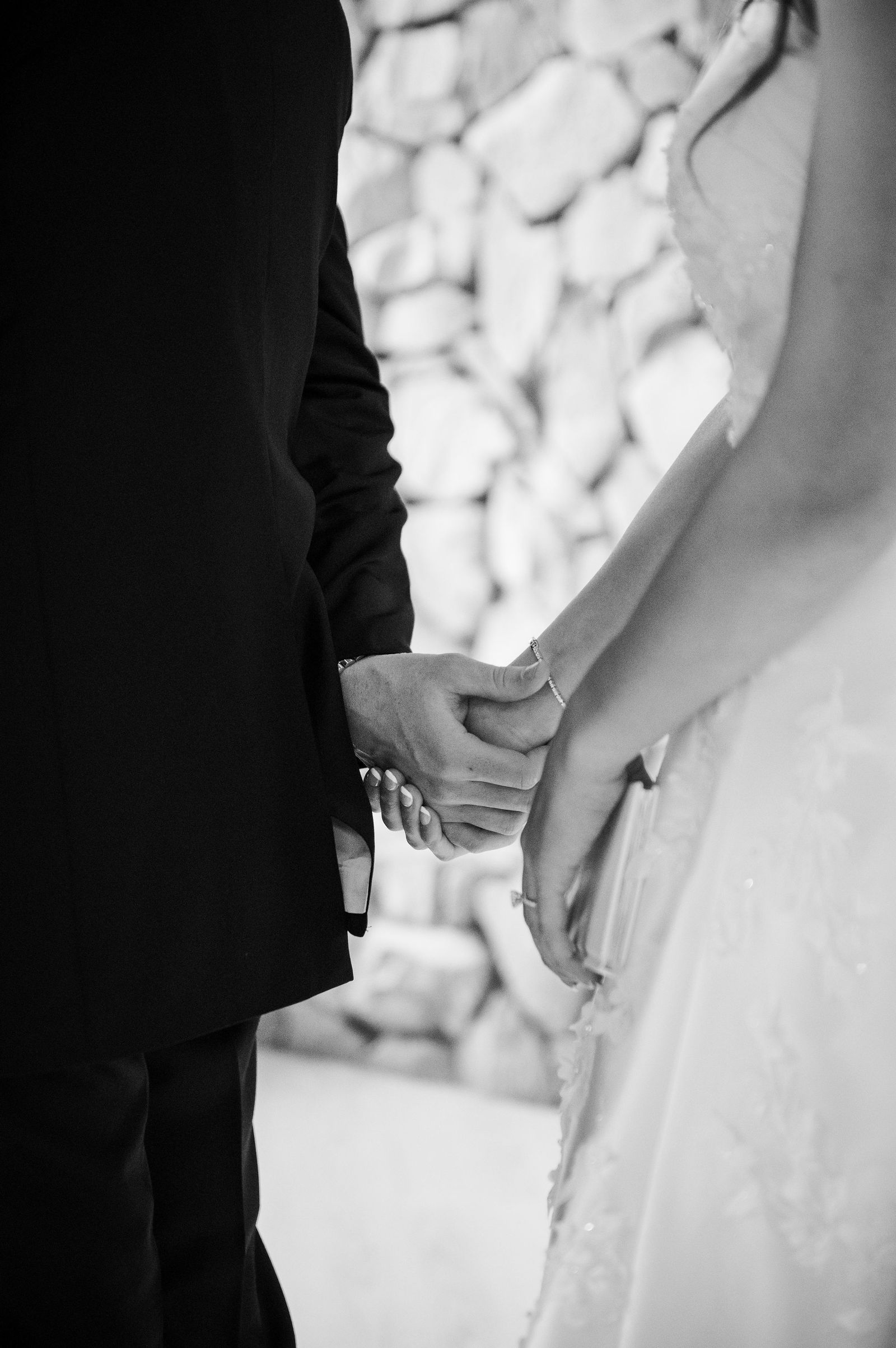 Bride and groom holding hands around a corner during a first touch in Colorado