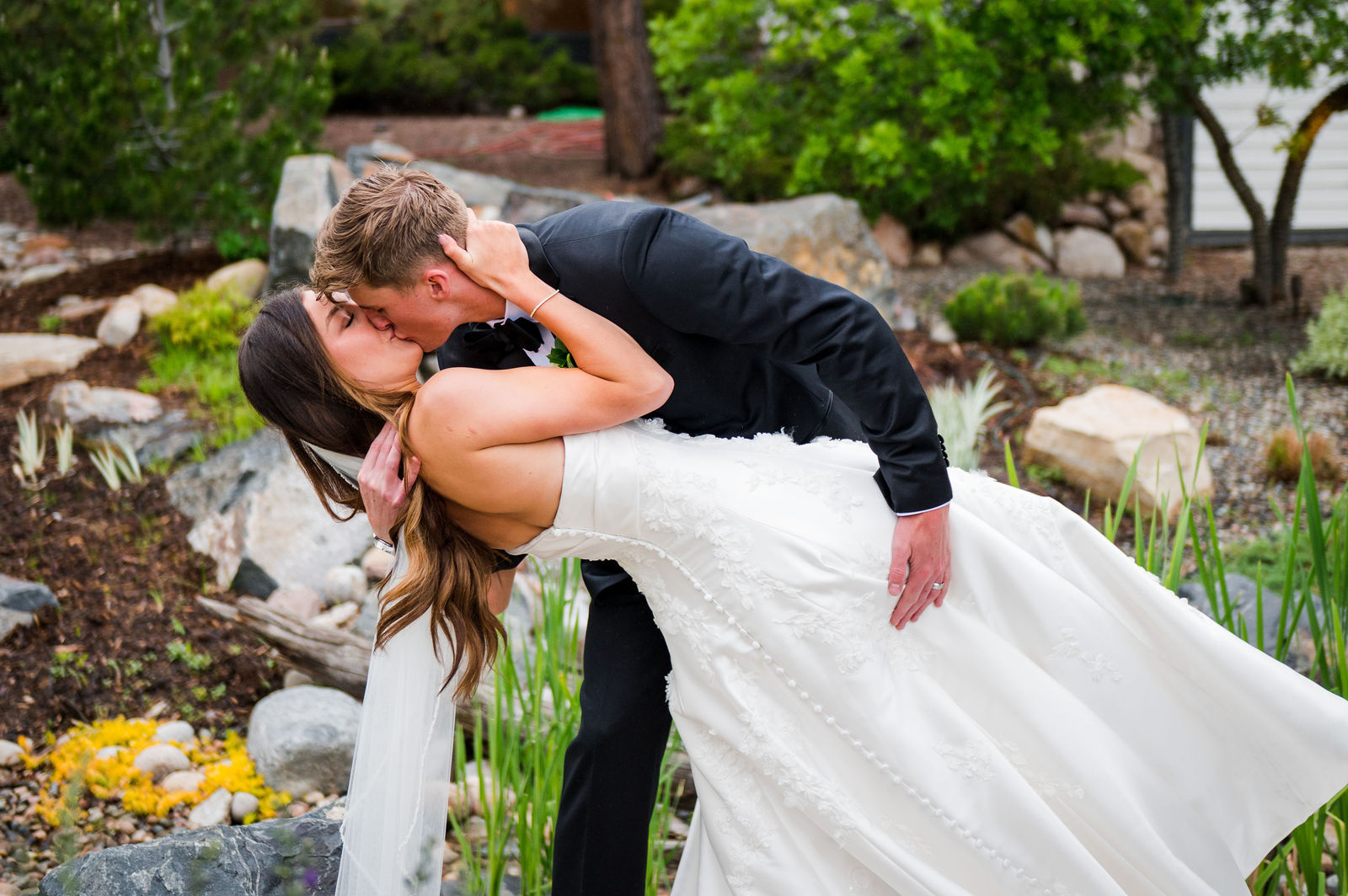 Groom dipping his bride for a kiss at The Oaks at Plum Creek Colorado