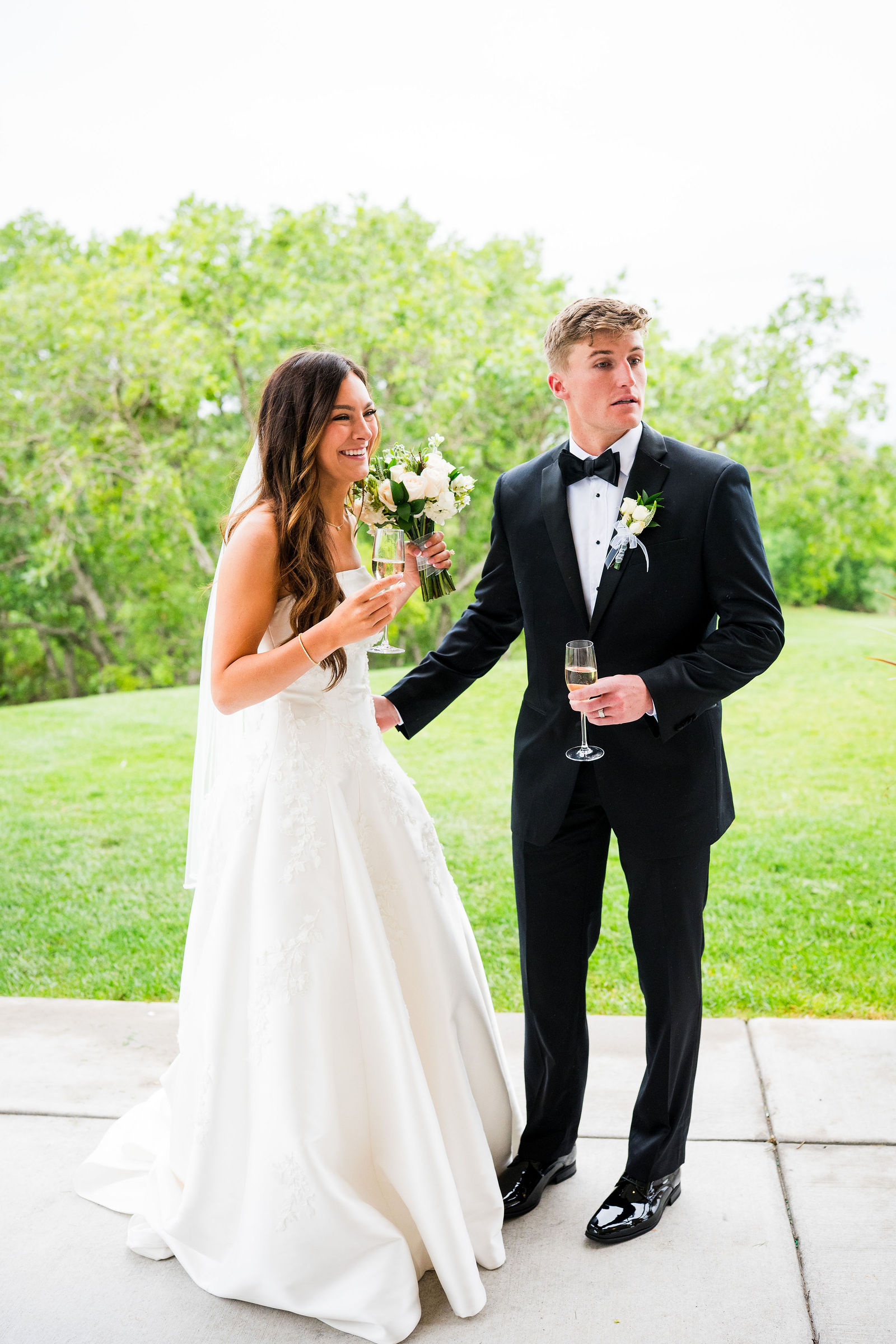 Bride and groom toasting champagne outside The Oaks at Plum Creek
