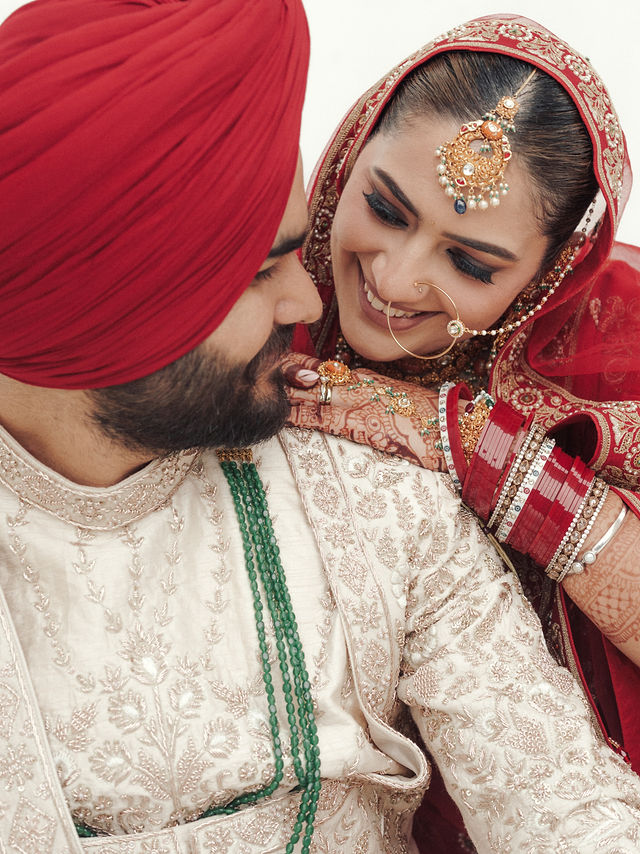 Avneet smiling down at Sarvan in a close wedding portrait