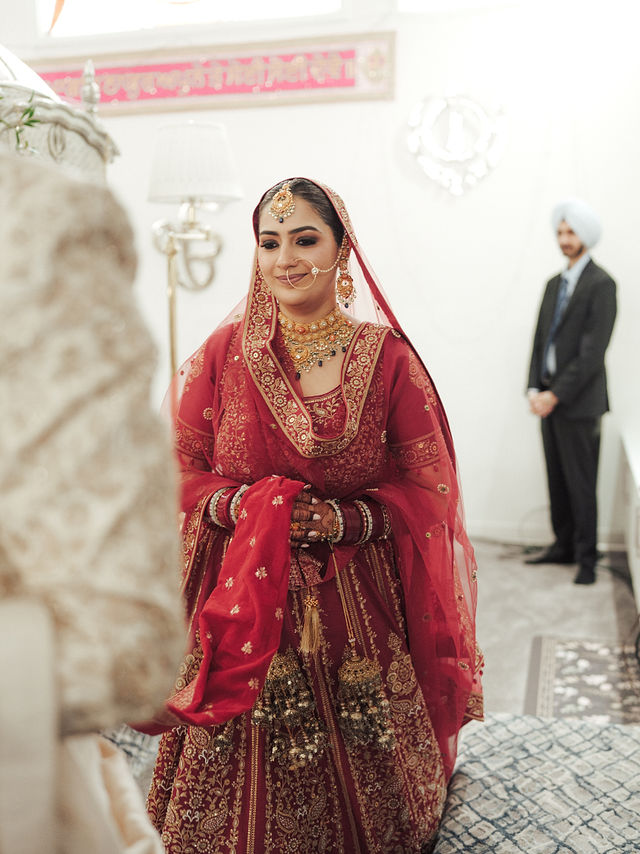 Avneet standing during the wedding ceremony in her red bridal outfit
