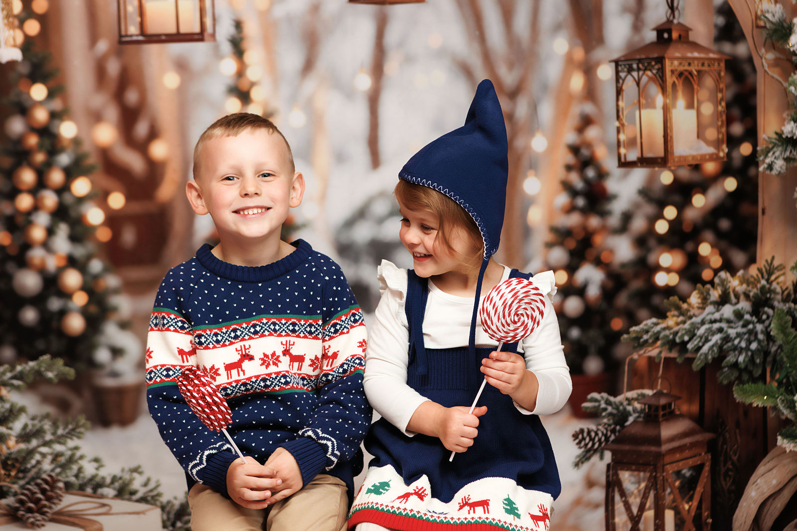 Young child holding a peppermint lollipop in a winter holiday setting