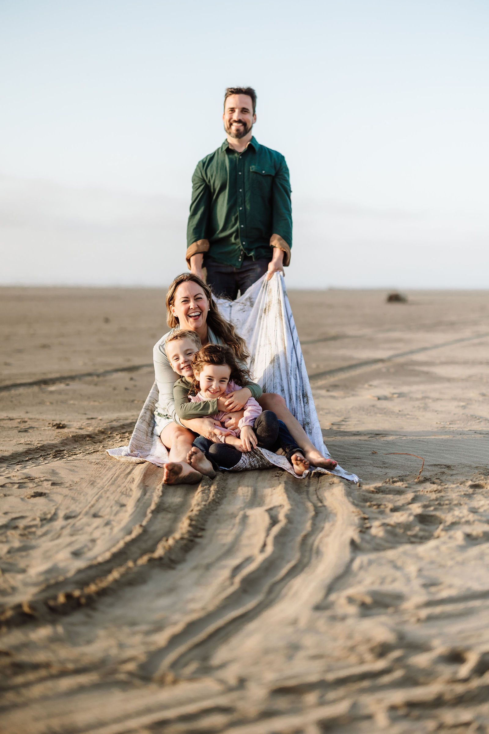 Family running together on the beach on the Oregon Coast