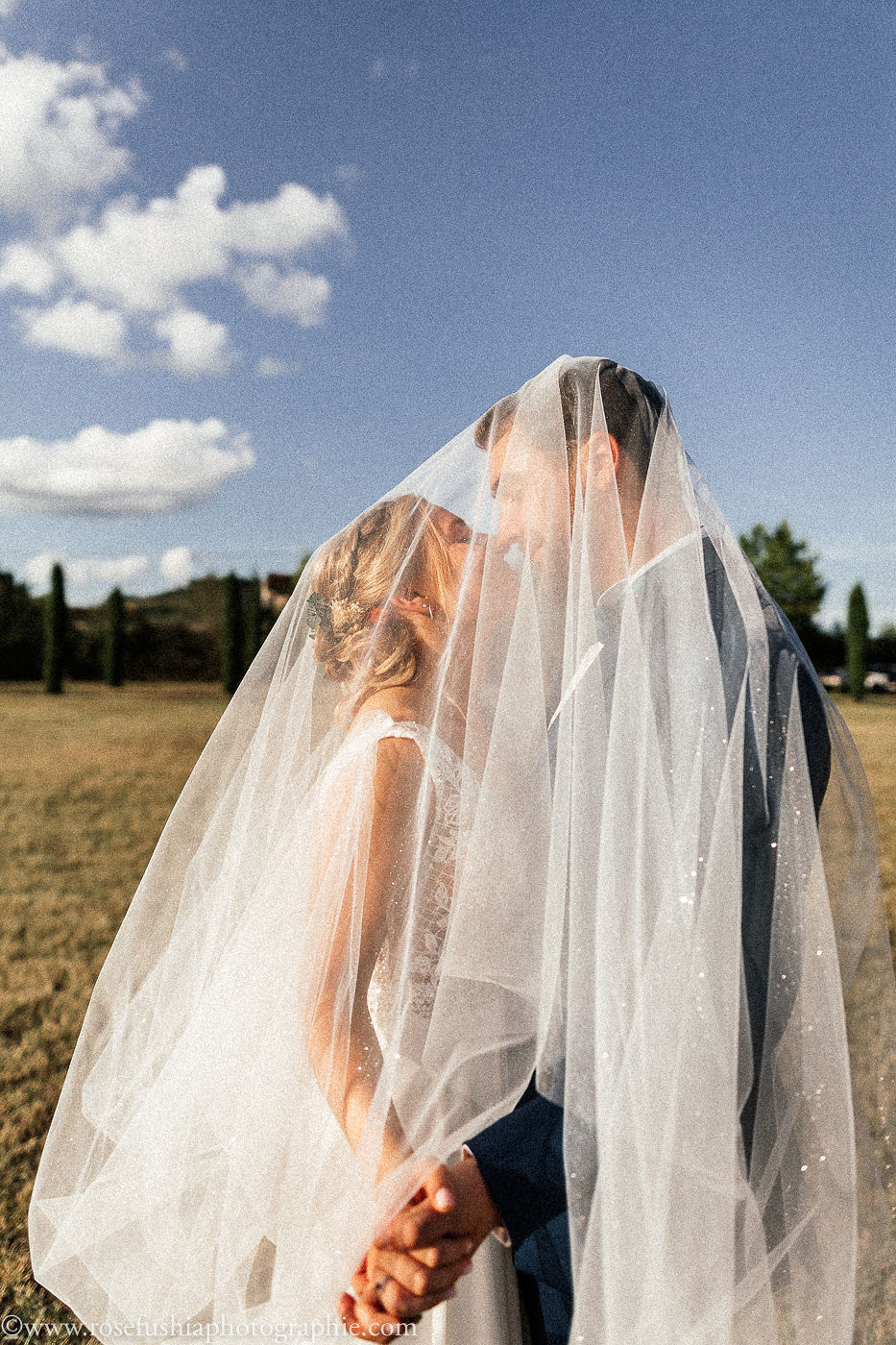 Photographe de mariage à Toulouse : les mariés sous le voile, sous un grand ciel bleu