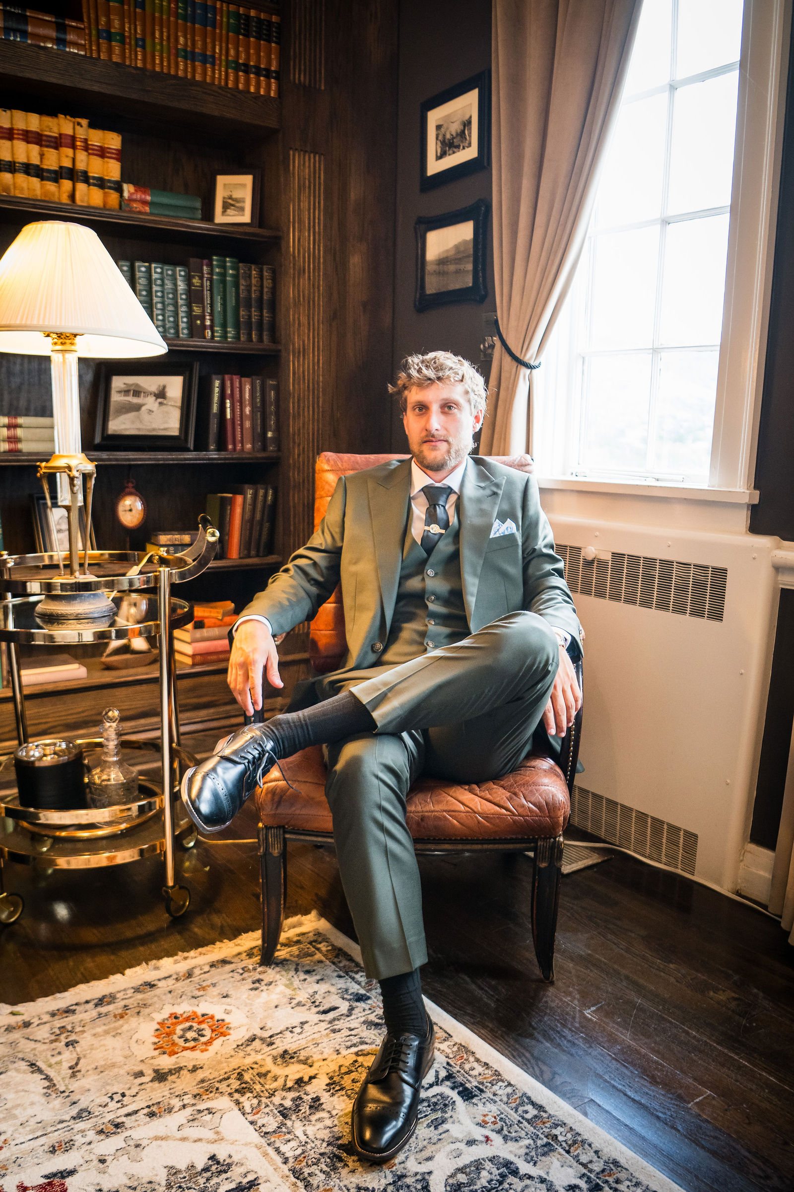 Groom seated in the library at the Manor House in Littleton