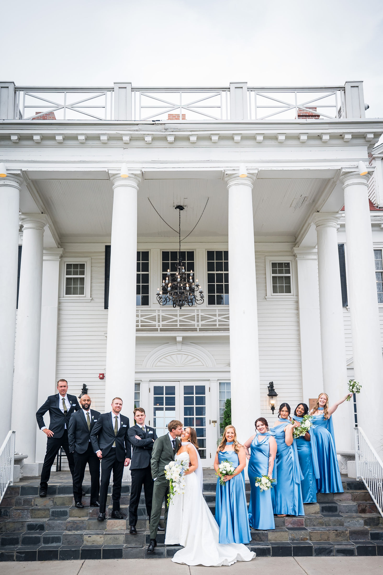 Whole wedding party on the columned steps of the Manor House