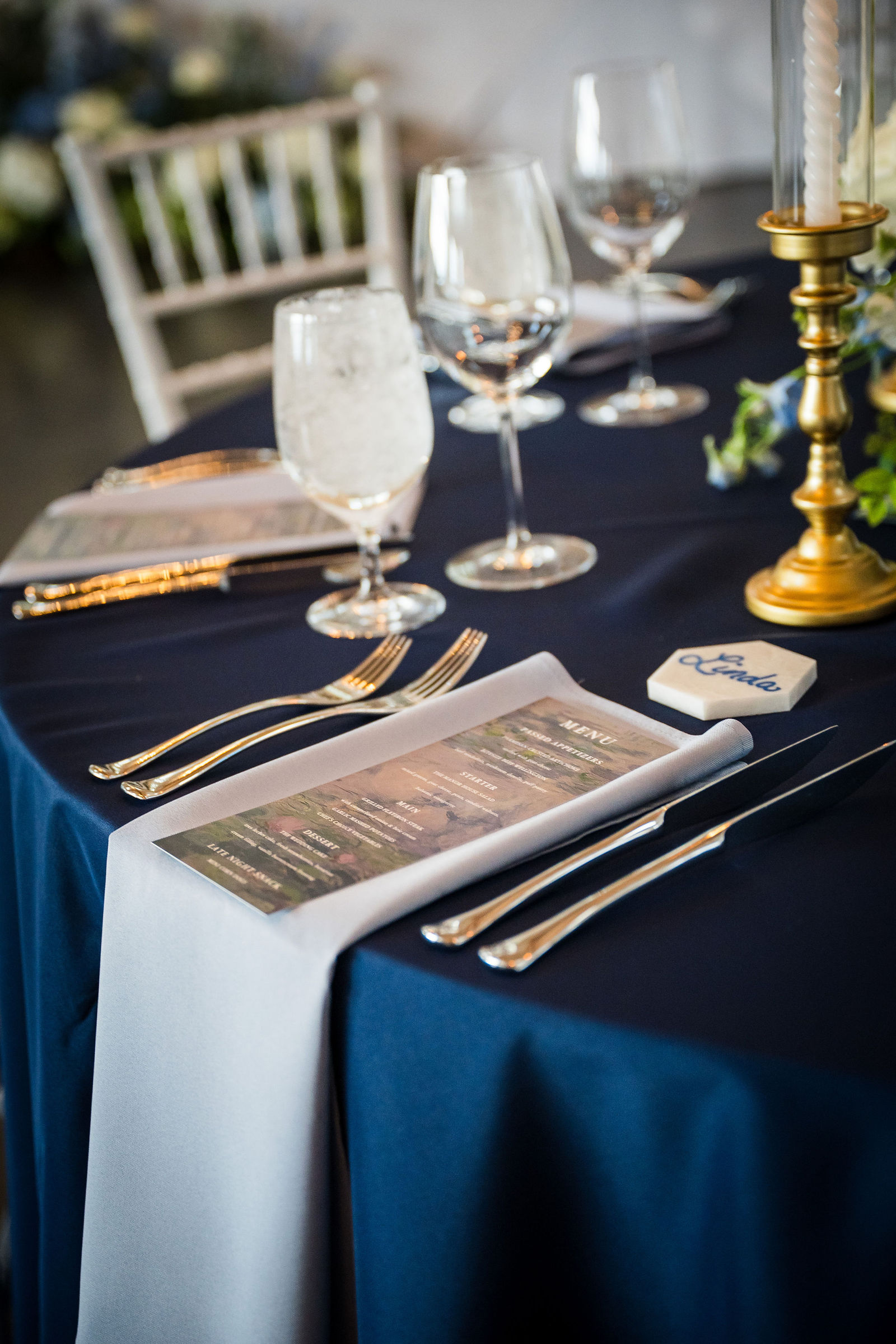 Navy place setting with gold candlesticks at a Manor House reception